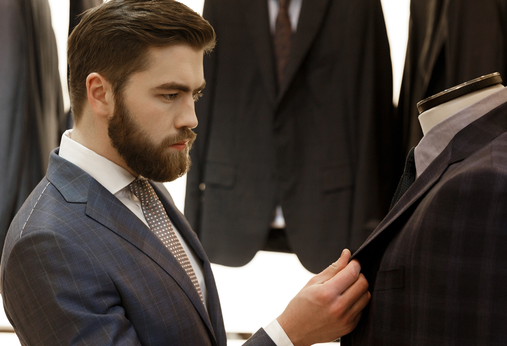 men checking various suit fabrics